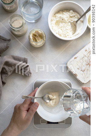 Homemade breadmaking with sourdough using wild yeast, busy lifestyle scene of baking at home, top view. Sustainable living Homemade breadmaking with sourdough using wild yeast, busy lifestyle scene of baking at home, top view. Sustainable living 90398142