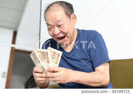 A smiling senior man with a wad of bills A smiling senior man with a wad of bills 90399723