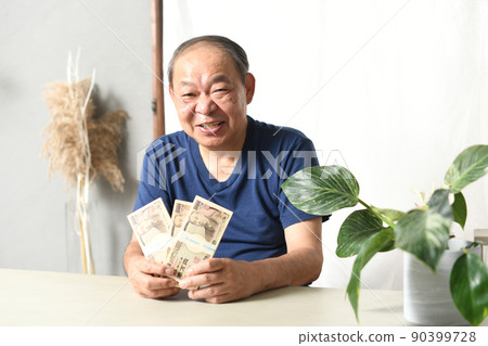 A smiling senior man with a wad of bills 90399728