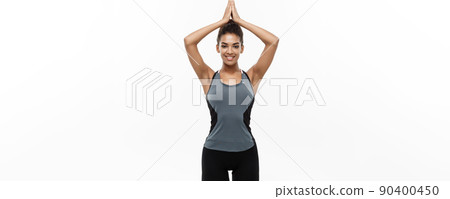 Healthy and Fitness concept - Beautiful American African lady in fitness clothing doing yoga and meditation. Isolated on white background. Healthy and Fitness concept - Beautiful American African lady in fitness clothing doing yoga and meditation. Isolated on white background. 90400450