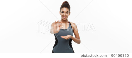 Healthy and Fitness concept - Closeup portrait of beautiful African American taking a pill of Cod liver oil. Isolated on white studio background. Healthy and Fitness concept - Closeup portrait of beautiful African American taking a pill of Cod liver oil. Isolated on white studio background. 90400520
