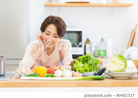 Middle-aged housewife in the kitchen 90402337