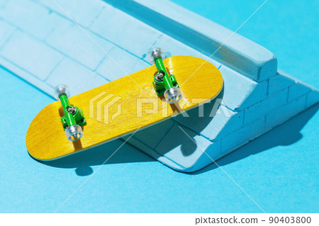 Yellow fingerboard and plaster ramp on a blue background 90403800