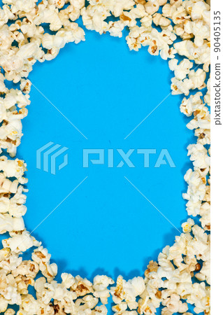 Popcorn on a blue background, corn kernels top view. Popcorn on a blue background, corn kernels top view. 90405135