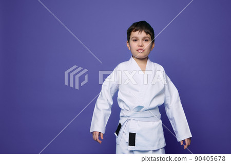 Charming confident aikido wrestler- Caucasian teenager in white kimono isolated on purple background with copy ad space. Oriental martial arts concept Charming confident aikido wrestler- Caucasian teenager in white kimono isolated on purple background with copy ad space. Oriental martial arts concept 90405678