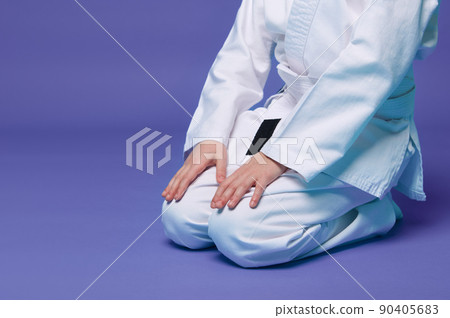 Cropped view of an aikido fighter in a white kimono during the practice of oriental martial arts, isolated over purple background with copy ad space 90405683