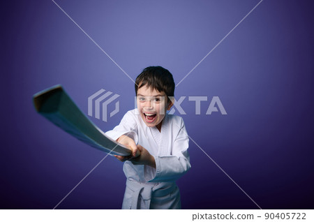 Confident strong European teenage boy aikido wrestler wearing traditional samurai hakama kimono learning fight with bamboo sword katana. Oriental martial arts Concept 90405722