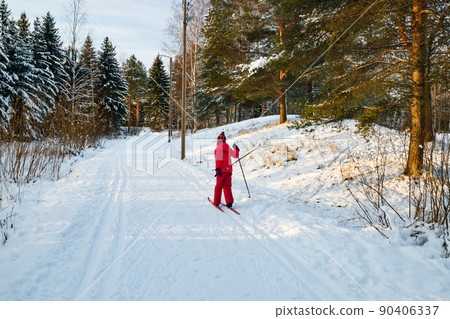 Small child in the ski track at winter forest in Finland. 90406337