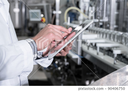 Factory worker inspecting production line on beverage factory with computer tablet. Factory worker inspecting production line on beverage factory with computer tablet. 90406750