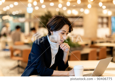 Middle-aged woman using a laptop in a fashionable office Middle-aged woman using a laptop in a fashionable office 90406775