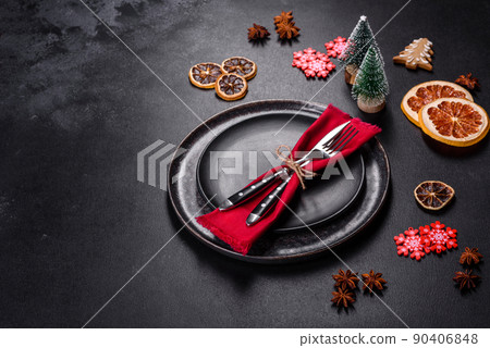 Christmas table setting with empty black ceramic plate, fir tree and black accessories 90406848