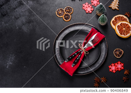 Christmas table setting with empty black ceramic plate, fir tree and black accessories 90406849
