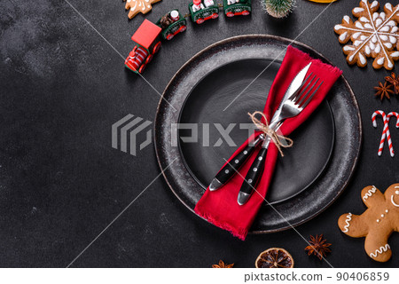 Christmas table setting with empty black ceramic plate, fir tree and black accessories Christmas table setting with empty black ceramic plate, fir tree and black accessories 90406859