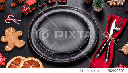 Christmas table setting with empty black ceramic plate, fir tree and black accessories 90406861