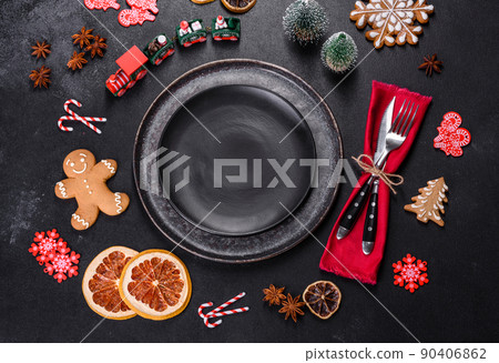Christmas table setting with empty black ceramic plate, fir tree and black accessories 90406862