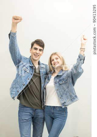 In the airport, a couple is awaiting boarding at lounge, people are waiting for their flights., a young joyful couple poses with their luggage. In the airport, a couple is awaiting boarding at lounge, people are waiting for their flights., a young joyful couple poses with their luggage. 90413295