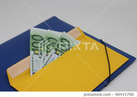 Banknotes in a yellow envelope on a light background. envelope banknotes. close up of an envelope Banknotes in a yellow envelope on a light background. envelope banknotes. close up of an envelope 90415700