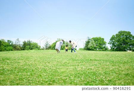 Family playing around on the green hill 90416291