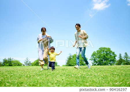 Family playing around on the green hill 90416297