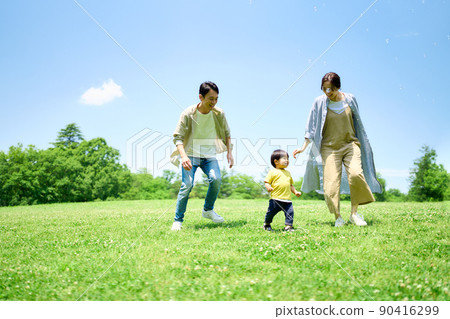 Family playing around on the green hill 90416299