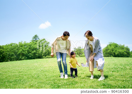 Family playing around on the green hill 90416300