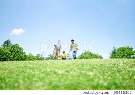 Family playing around on the green hill 90416302