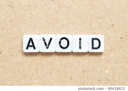 White tile alphabet letter with word avoid on wood background 90416823