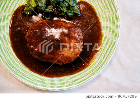 Hamburger with demiglace sauce on a green plate 90417299