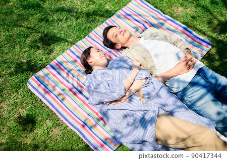 Couple taking a nap on the grass Couple taking a nap on the grass 90417344