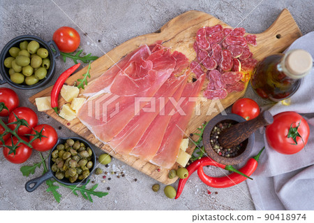 Meat antipasto platter on stone table - Sliced fuet salami sausage, prosciutto or jamon ham Meat antipasto platter on stone table - Sliced fuet salami sausage, prosciutto or jamon ham 90418974