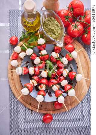 Caprese salad - Mini mozzarella cheese in glass bowl, tomato and basil Caprese salad - Mini mozzarella cheese in glass bowl, tomato and basil 90418975