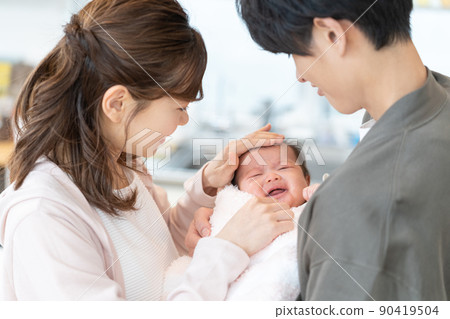Young mom and dad worried about crying baby 90419504