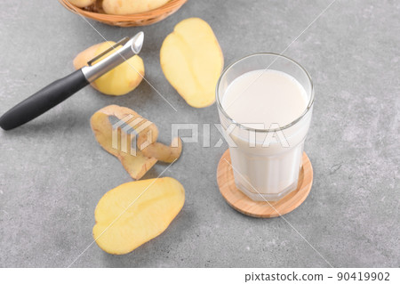 Vegan potato milk and potato on grey stone table background. Plant based alternative milk replacer and lactose free 90419902