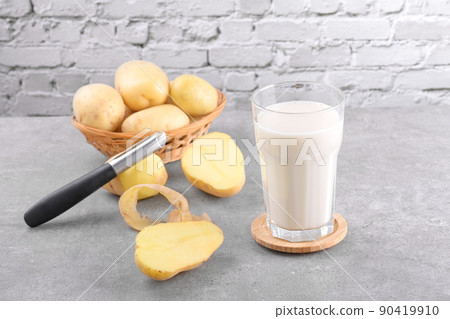 Vegan potato milk and potato on grey stone table background. Plant based alternative milk replacer and lactose free 90419910