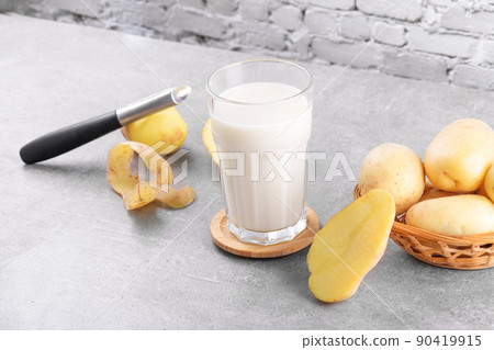 Vegan potato milk and potato on grey stone table background. Plant based alternative milk replacer and lactose free 90419915