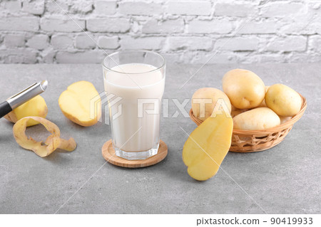 Vegan potato milk and potato on grey stone table background. Plant based alternative milk replacer and lactose free 90419933