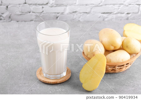 Vegan potato milk and potato on grey stone table background. Plant based alternative milk replacer and lactose free 90419934