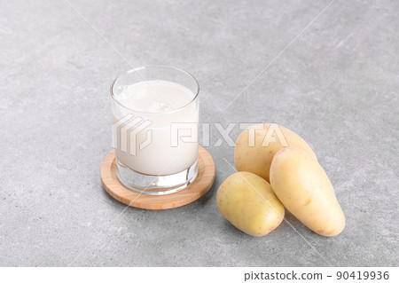 Vegan potato milk and potato on grey stone table background. Plant based alternative milk replacer and lactose free 90419936