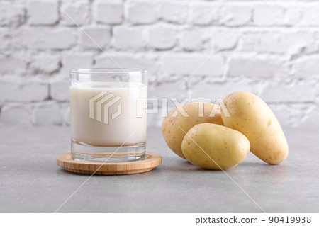 Vegan potato milk and potato on grey stone table background. Plant based alternative milk replacer and lactose free 90419938