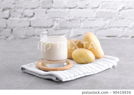 Vegan potato milk and potato on grey stone table background. Plant based alternative milk replacer and lactose free 90419939
