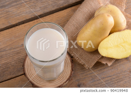 Vegan potato milk and potato on rustic wooden background. Plant based alternative milk replacer and lactose free 90419948