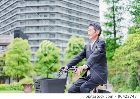 Elderly businessman commuting by bicycle 90422748