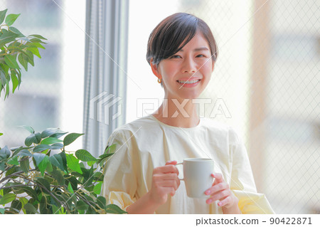 Woman holding a cup with both hands 1 Woman holding a cup with both hands 1 90422871