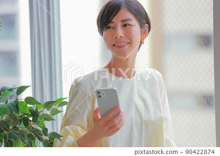 一個拿著智能手機微笑的女人 1 90422874