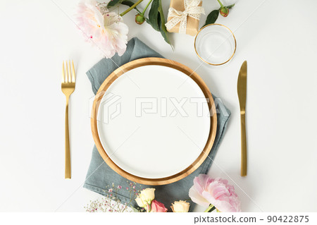Beautiful table setting with golden cutlery and peony flowers, mock up 90422875