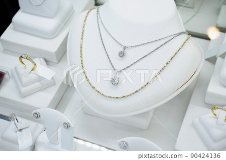 Jewelry diamond shop with rings and necklaces luxury retail store window display Jewelry diamond shop with rings and necklaces luxury retail store window display 90424136