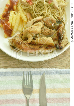 grilled chicken black pepper steak dressing spicy sauce with French fries and fried spaghetti sausage on plate 90428310