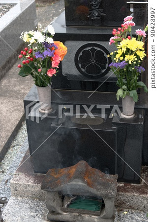 Offering flowers and incense sticks (Buddha flowers) when visiting a grave Offering flowers and incense sticks (Buddha flowers) when visiting a grave 90428997