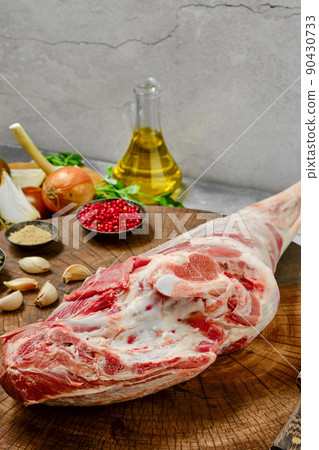 Raw whole lamb leg chump on with ingredients closeup Raw whole lamb leg chump on with ingredients closeup 90430733
