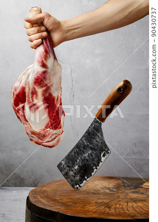 Butcher hold raw lamb shoulder chump over cutting log Butcher hold raw lamb shoulder chump over cutting log 90430737